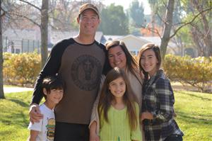 A family of 5 hugging and smiling together
